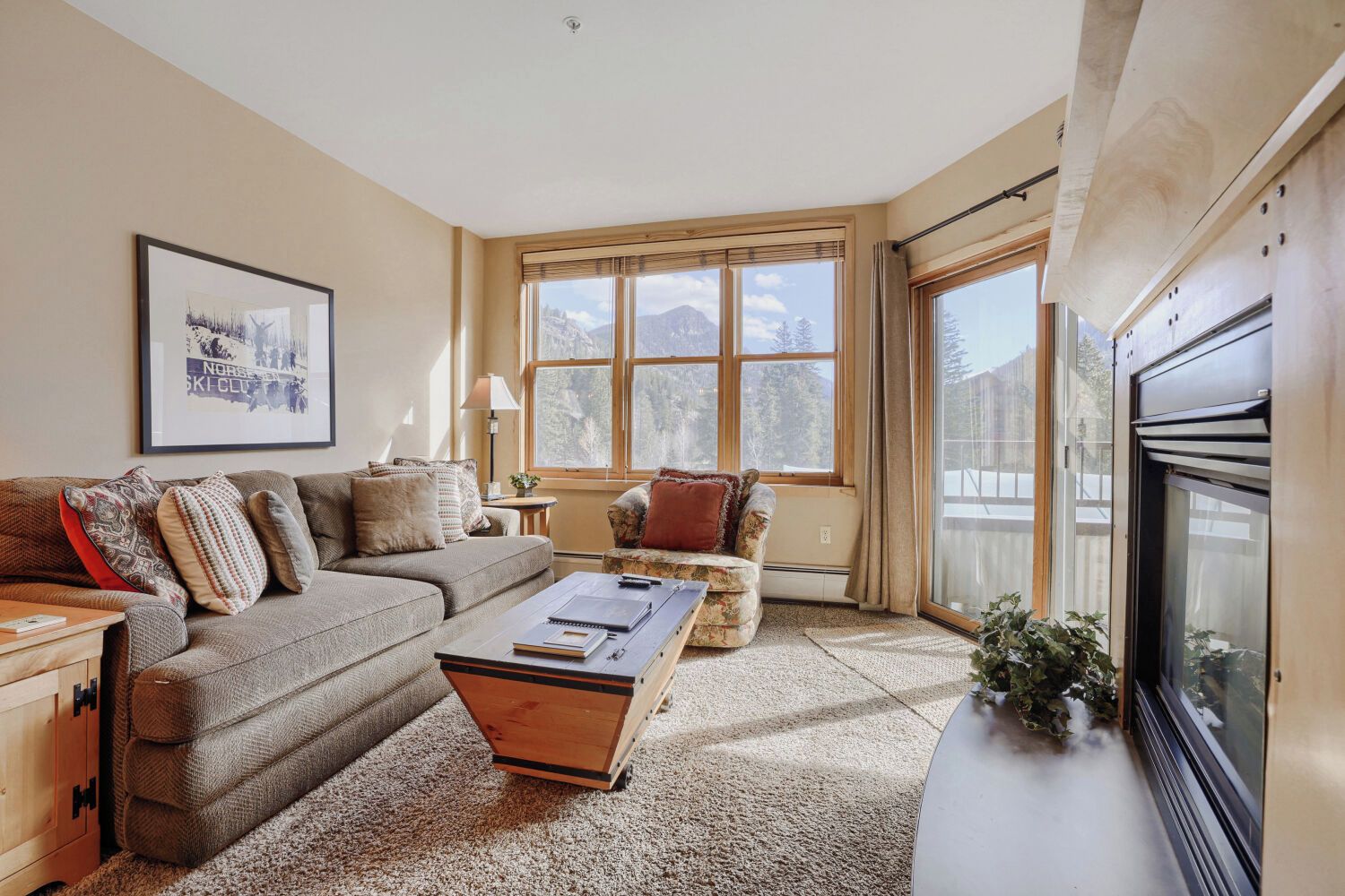 A cozy living room with a sofa, a coffee table, and a fireplace.