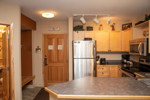 Enjoy cooking in this well-equipped kitchen with a refrigerator, oven, sink, and coffee maker.