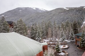 Eine Lodge mit großzügiger Überdachung, einer Seilbahn und einer Bergkulisse.