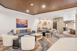 A modern lounge area with a sofa, armchairs, and a coffee table.