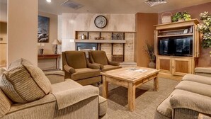 Una sala de estar acogedora con chimenea, asientos cómodos y un televisor.