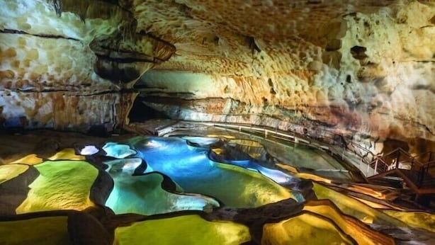 Interno di una grotta con una piscina naturale e stalattiti.
