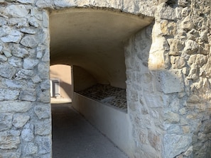 Simple, rustic accommodations with a bed and passageway.
