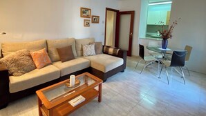 A living room with a sofa, coffee table, and dining area with chairs and a table. - La Terrassa del Barri Vell de Girona (Girona)