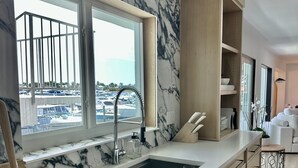 Eine moderne Küche mit großem Fenster, Marmor-Spritzschutz und Holzschränken.