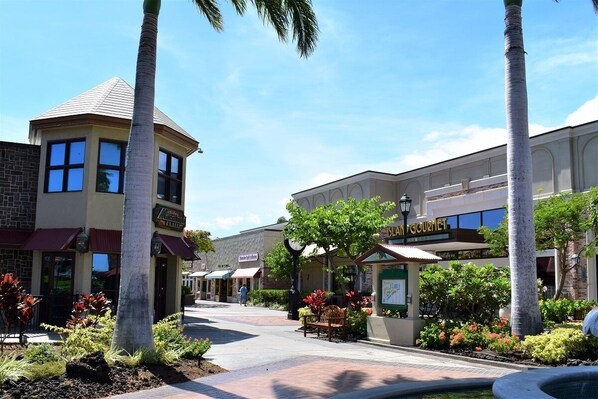 A street view with a building labeled "SANDGOURMET" and a palm tree-lined walkway.