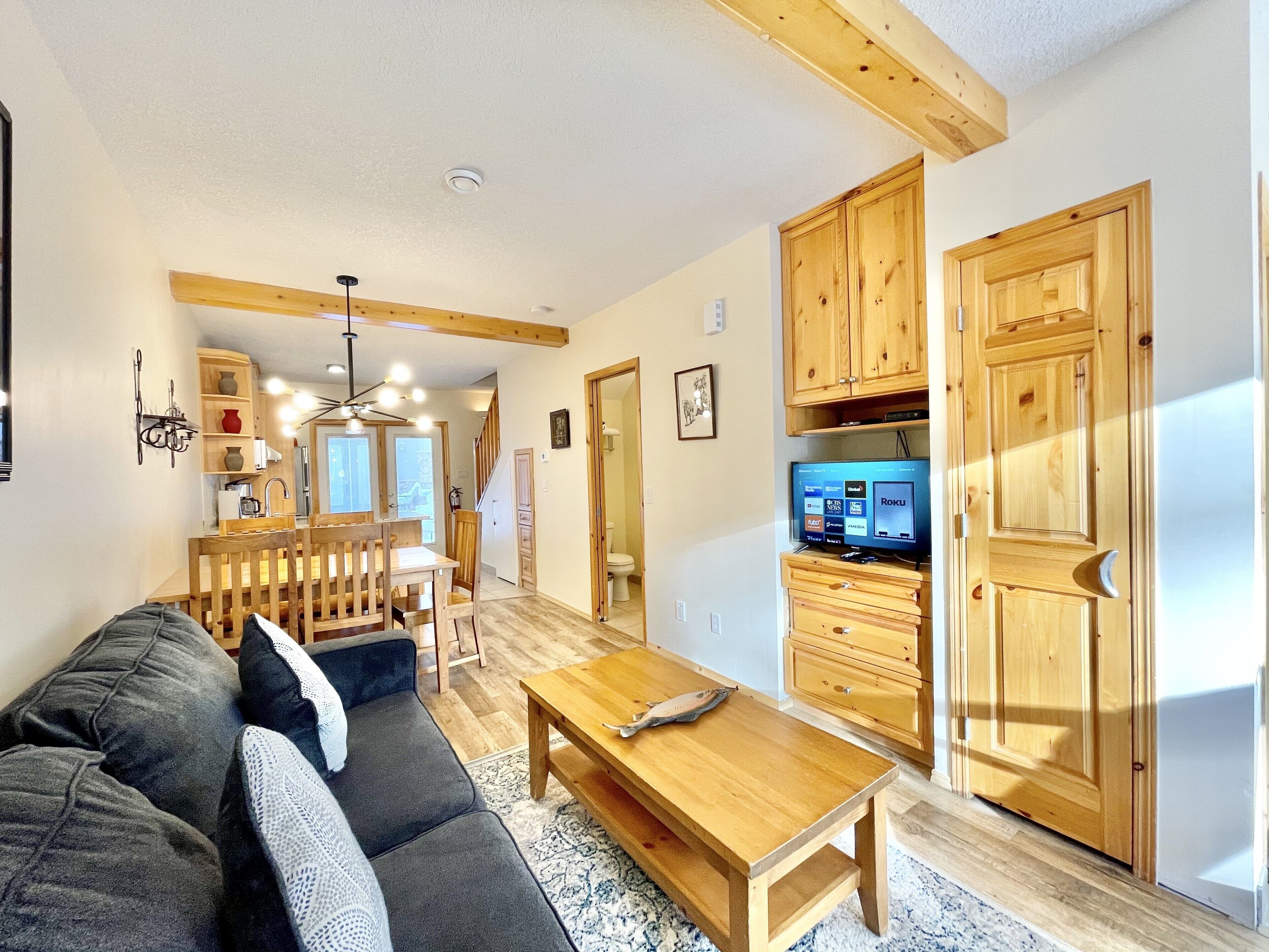 Un salon comprenant un canapé, une table basse, des meubles en bois et un téléviseur.