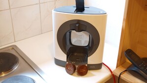 Et køkken med kaffemaskine, elkedel og brødrister på bordet.