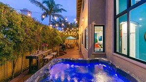 A hot tub in a backyard with string lights and a patio area. - Casa Surfside-Walk 2 Beach, Spa, Close to Legoland (Carlsbad)