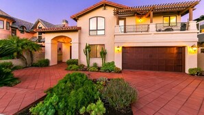 A two-story house with a garage, a balcony, and a well-maintained garden. - Casa Surfside-Walk 2 Beach, Spa, Close to Legoland (Carlsbad)