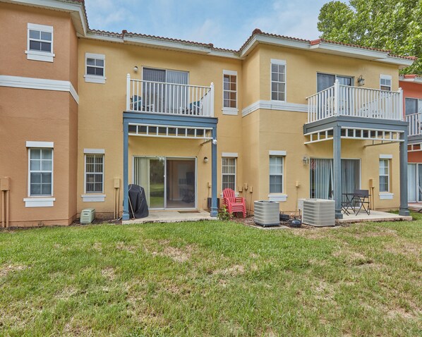 A two-story residential building with a flat roof, multiple windows, and balconies. - Fall Retreat near Disney, Perfect for families (Kissimmee)