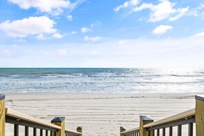 Une plage avec une promenade en bois qui mène à l’eau.