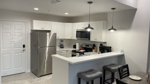 Enjoy cooking in this kitchen with a central island, bar stools, and ample workspace.