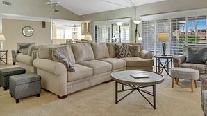 A spacious living room with a beige sofa, a coffee table, and a ceiling fan. - Great resort living in Palm Desert (Palm Desert)