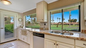 A kitchen with a large window, a dishwasher, and a sink. - Great resort living in Palm Desert (Palm Desert)