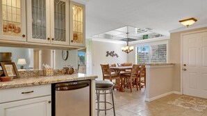 A kitchen with a dining area, featuring a kitchen island, bar stools, and a chandelier. - Great resort living in Palm Desert (Palm Desert)