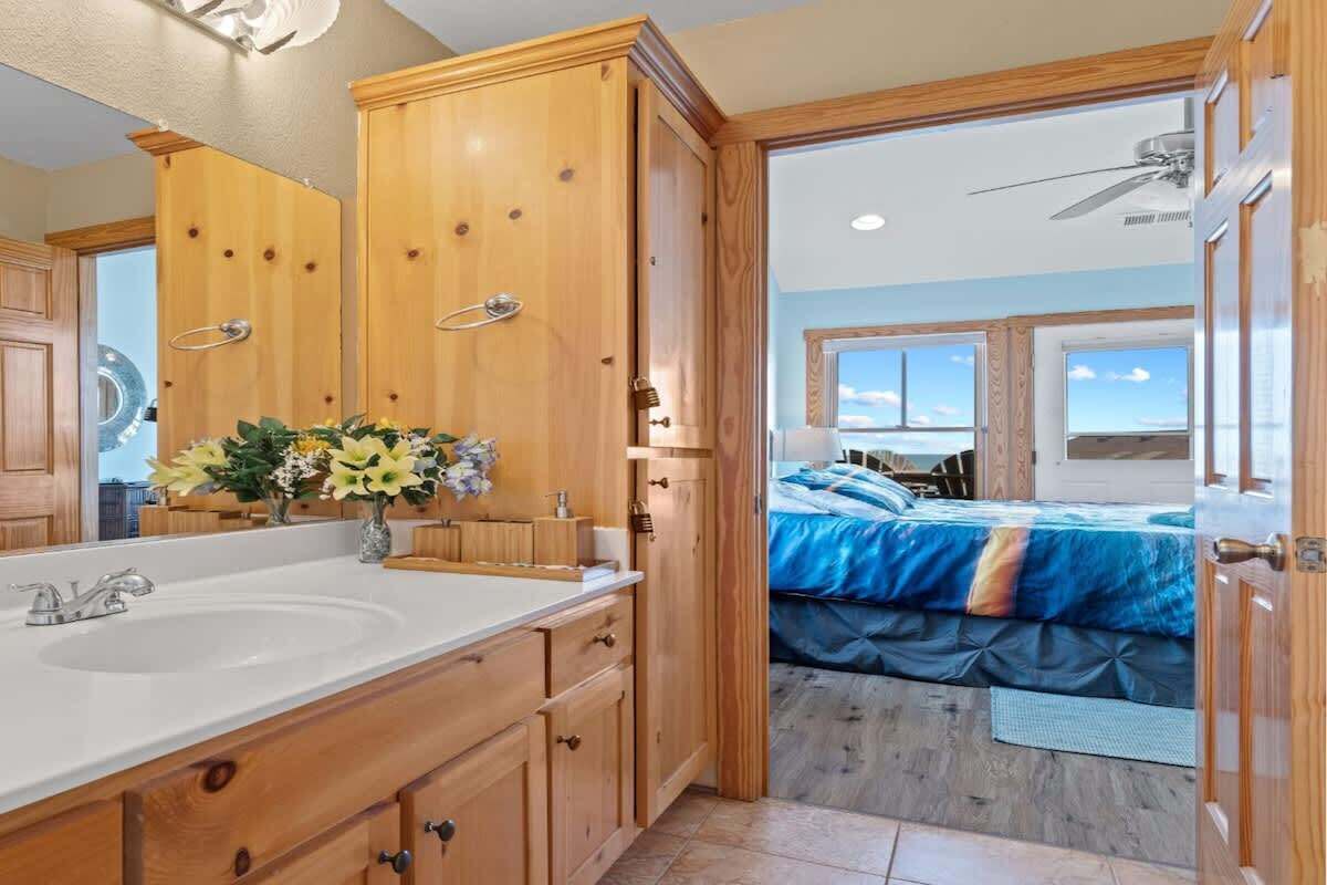 Une salle de bain avec des meubles en bois, un lavabo et un miroir.