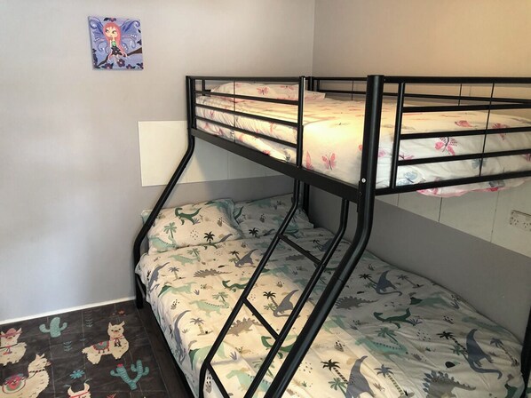 Cozy retreat with a bunk bed and floral-patterned mattress, featuring a colorful artwork above.