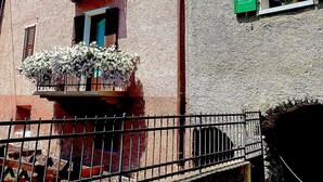 Un edificio con balcones, jardineras y una valla de metal.