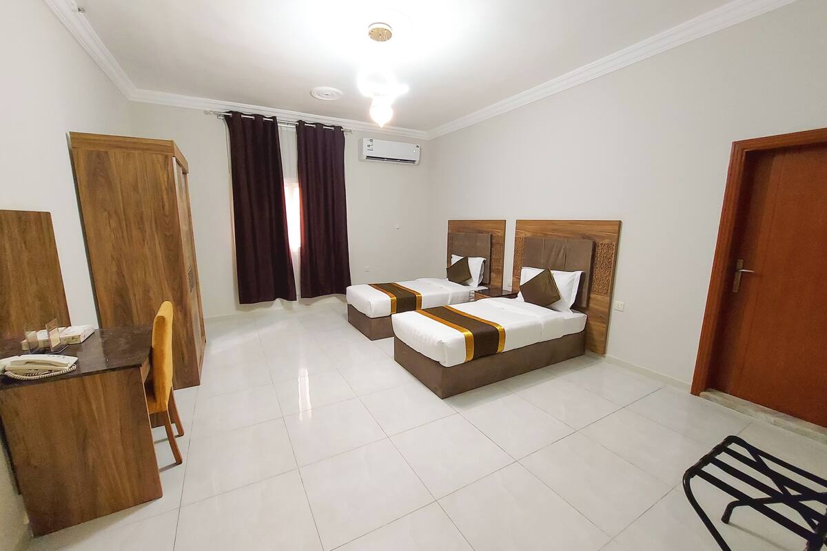 Una habitación de hotel con cama, escritorio, silla y armario.