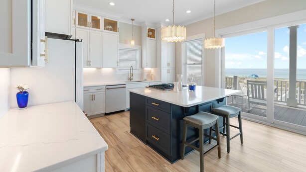 A modern kitchen with a large island, white cabinets, and a view of the ocean. - "Be Shell-Fish" Oceanfront, 6 Bedrooms, 4.5 Bathrooms (Supply)