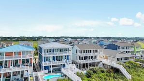 A coastal residential area with multi-story houses featuring balconies and a swimming pool. - "Be Shell-Fish" Oceanfront, 6 Bedrooms, 4.5 Bathrooms (Supply)