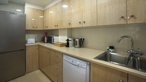 Una cocina moderna con armarios de madera, electrodomésticos de acero inoxidable y lavavajillas.