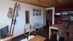 Un salon chaleureux avec des meubles en bois, un téléviseur et du matériel de ski accroché au mur.