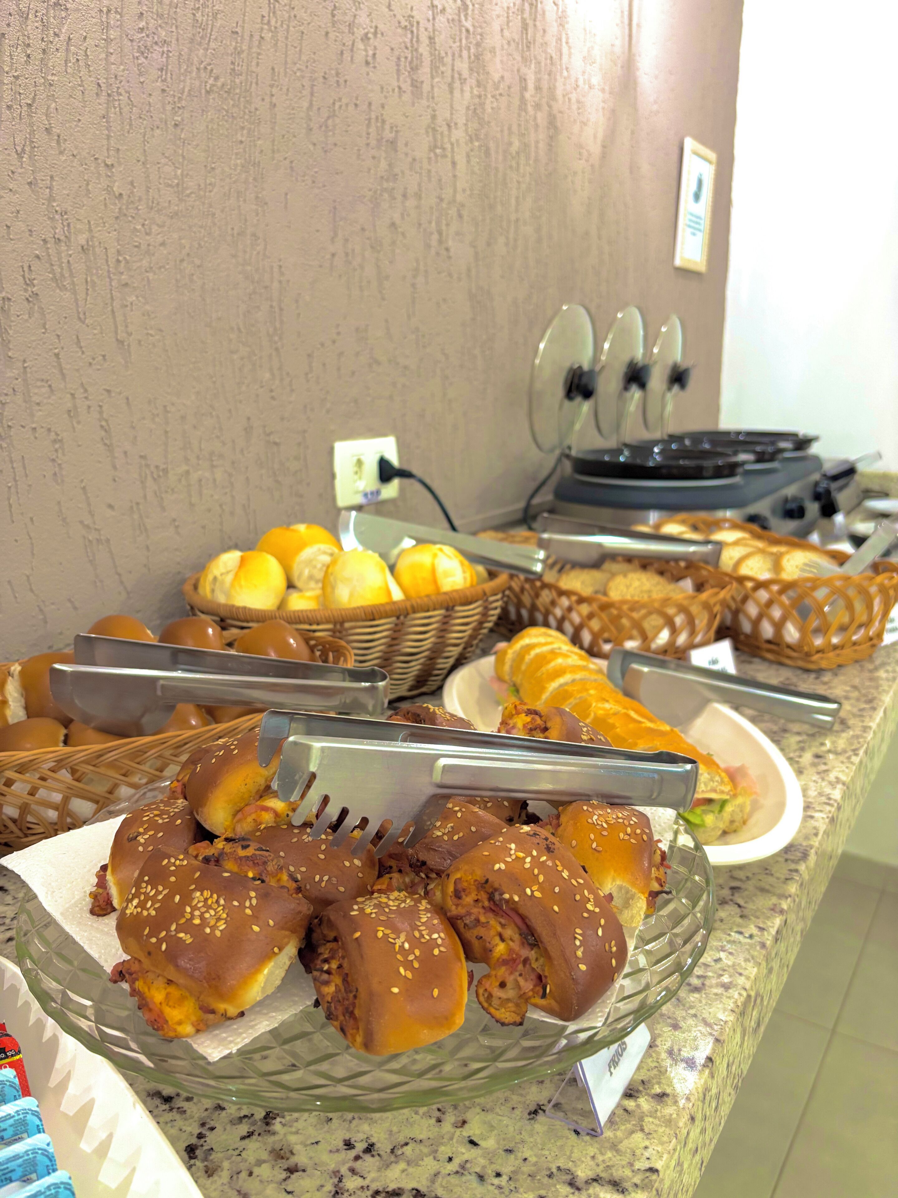 Een buffet met diverse gerechten, waaronder sandwiches, broodjes en gebak.