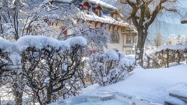 A hot tub in a snowy outdoor setting with a mountain backdrop.
