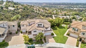 A residential area with houses featuring tiled roofs and well-maintained lawns. - Short/Long Term Fully Furnished Rental (Carlsbad)