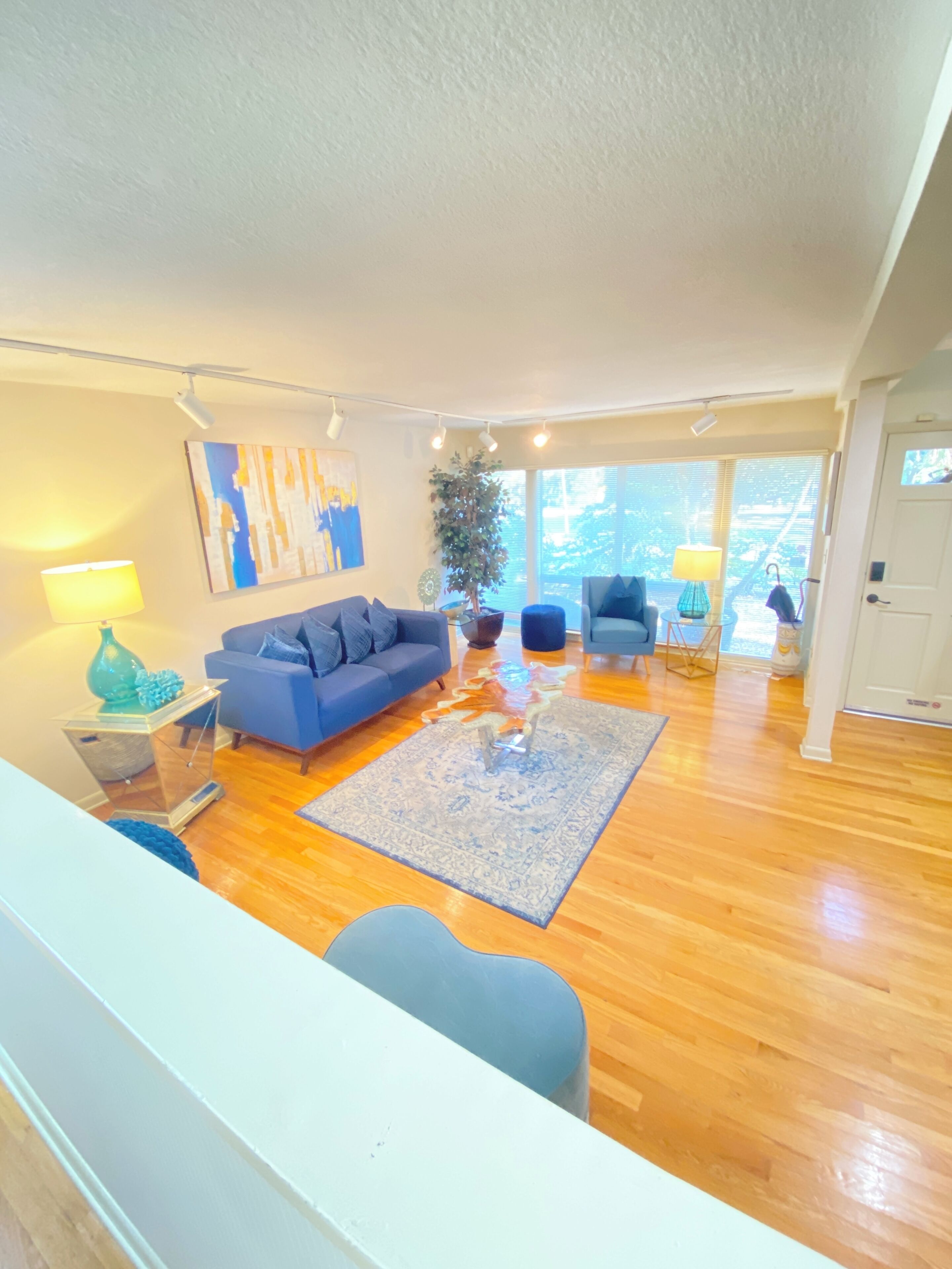 A modern living room with a blue sofa, a coffee table, and a patterned rug.