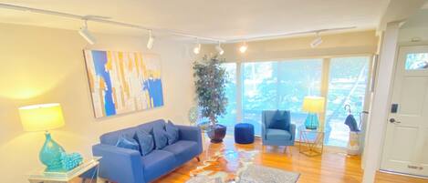 A modern living room with a blue sofa, a coffee table, and a patterned rug.