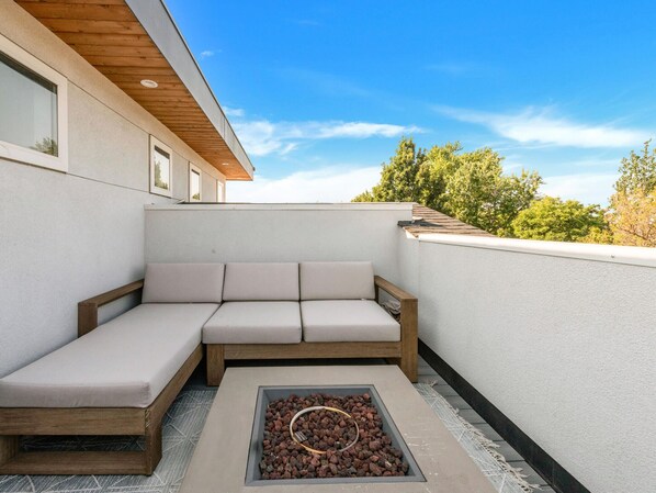 Un espacio moderno para sentarse al aire libre con una chimenea integrada.