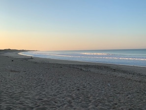 Una spiaggia con un'ampia distesa di sabbia e onde tranquille.