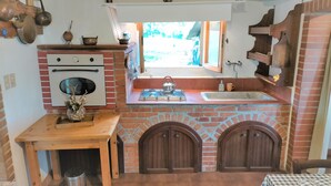 Eine kompakte Küche mit Backofen, Spüle und einem kleinen Esstisch.