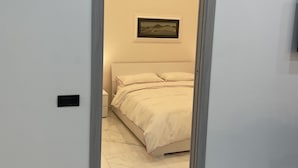 Une chambre à coucher avec un lit, une table de chevet et un luminaire fixé au mur.