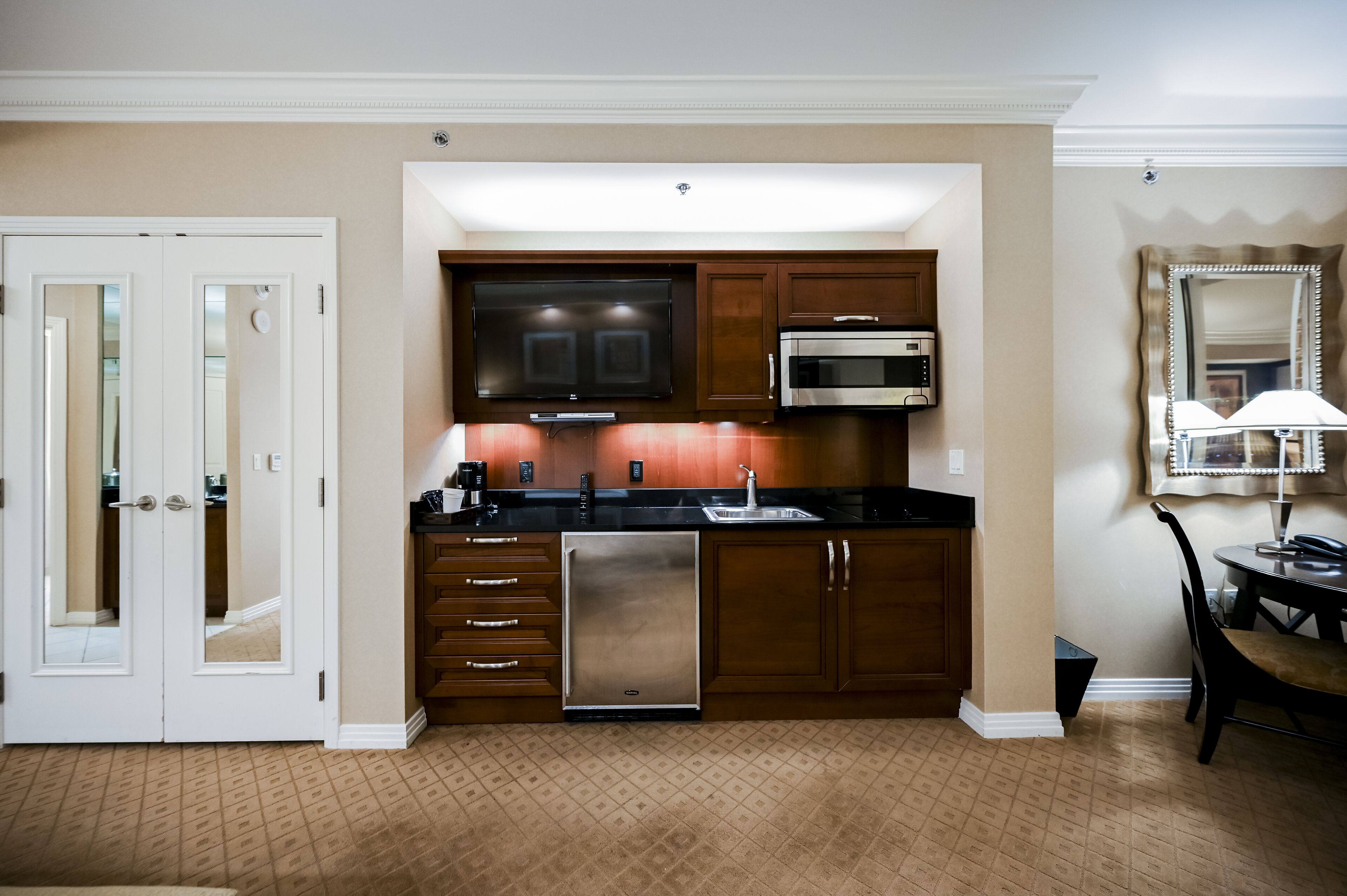 A compact kitchen with a refrigerator, microwave, and built-in oven.