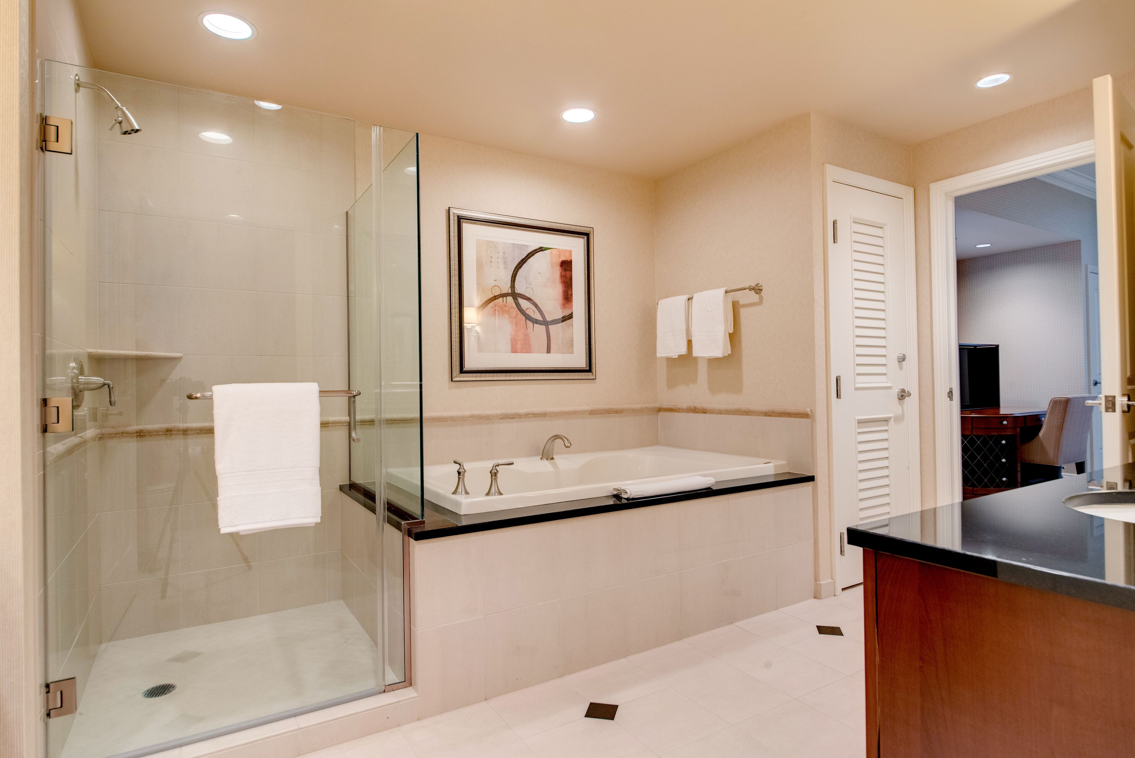 Un bagno moderno con doccia vetrata, una vasca da bagno indipendente e un mobile lavabo con piano.