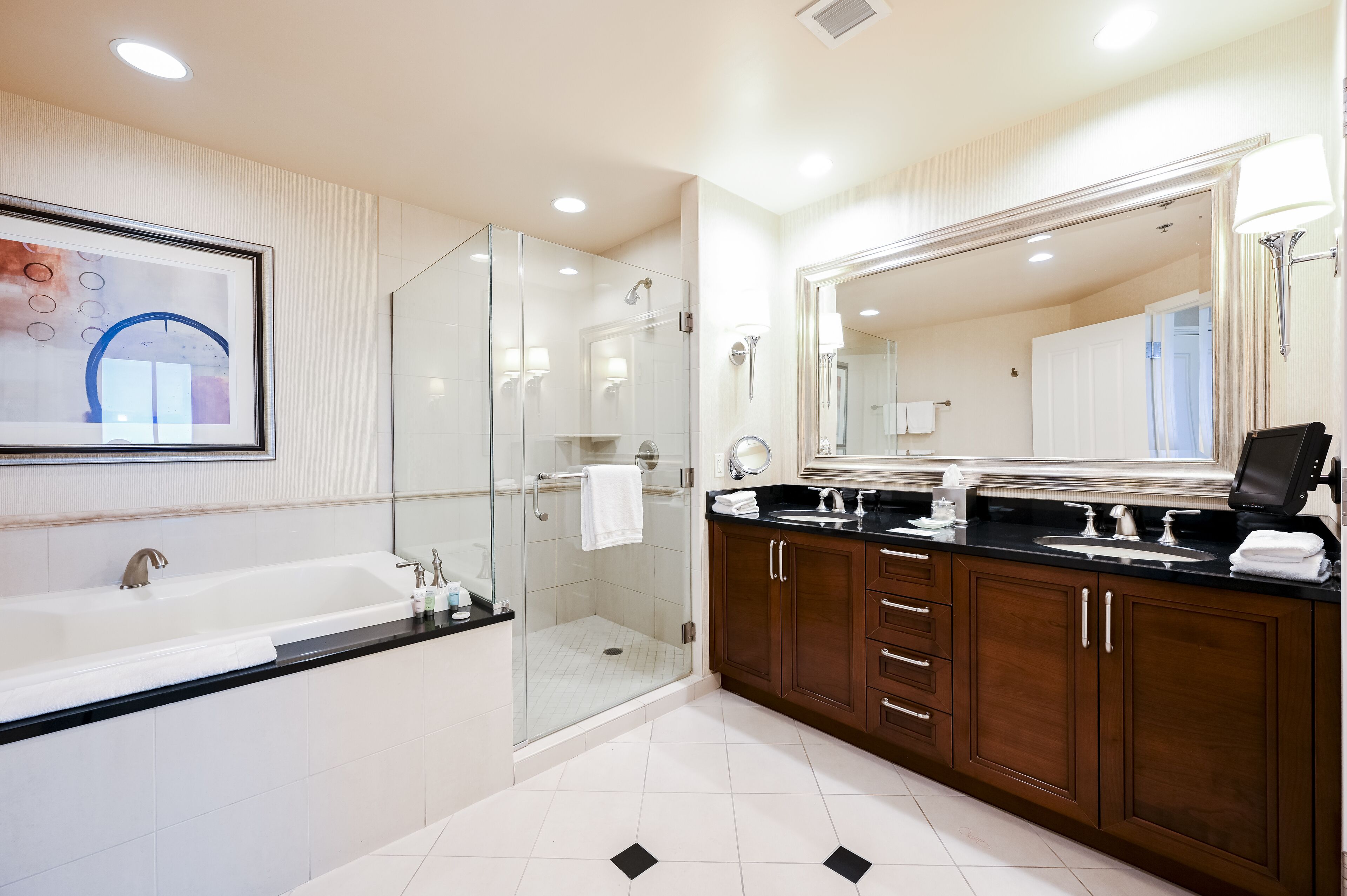 A modern bathroom with a glass-enclosed shower, a large mirror, and a double sink vanity.