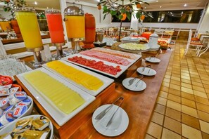 A buffet with various food items and beverages. - Flat Plaza Hotel - Setor de Hotéis Norte (Brasília)