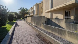 A residential building with a paved walkway, concrete walls, and a clear sky. - HostWise - Seaside Beach Flat (Vila Nova de Gaia)