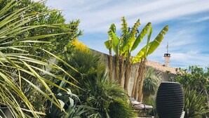 Un jardin agrémenté de diverses plantes, d’un banc et d’une grande sculpture décorative.