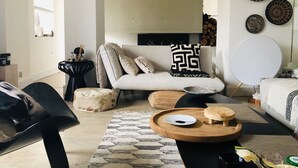Un salon moderne avec un canapé, une table basse et des œuvres d’art décoratives au mur.