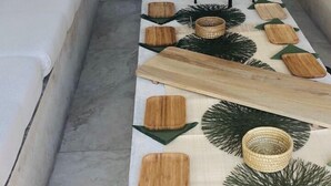 Un salon moderne avec une longue table basse en bois, un canapé et un téléviseur fixé au mur.