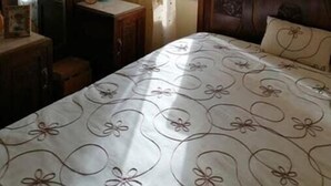 Un dormitorio con cama, cómoda, espejo y ventana con cortinas.