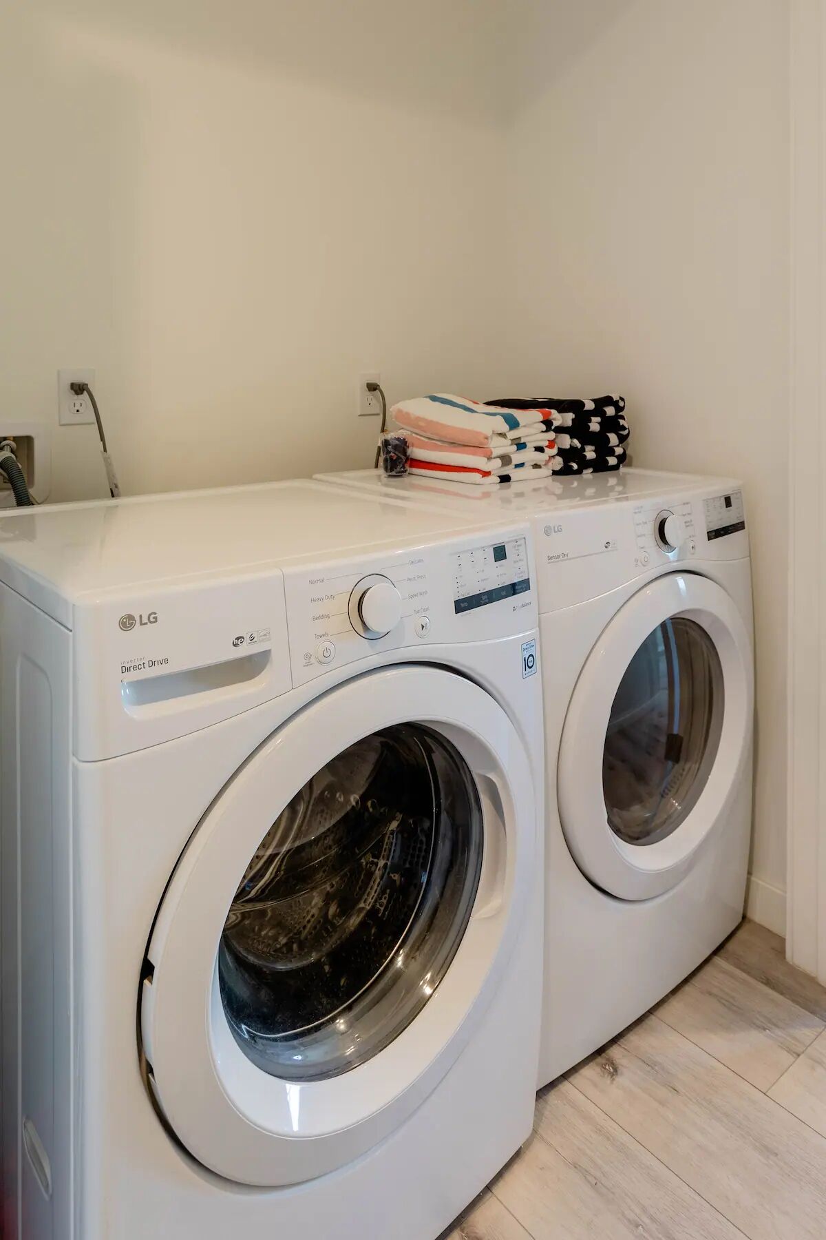 A laundry area with two white LG Direct Drive washing machines.
