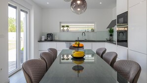 A modern kitchen with a central island, a coffee machine, and a fruit bowl. - Lovely home in Donji Prolozac (Donji Prolozac)