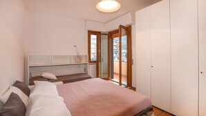 Un dormitorio con cama, mesita de noche y vistas al exterior a través de un ventanal.