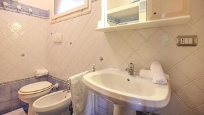 A bathroom with a toilet, bidet, and sink. - 1 bedroom cozy home in Costa Rei -CA- (Costa Rei -CA-)